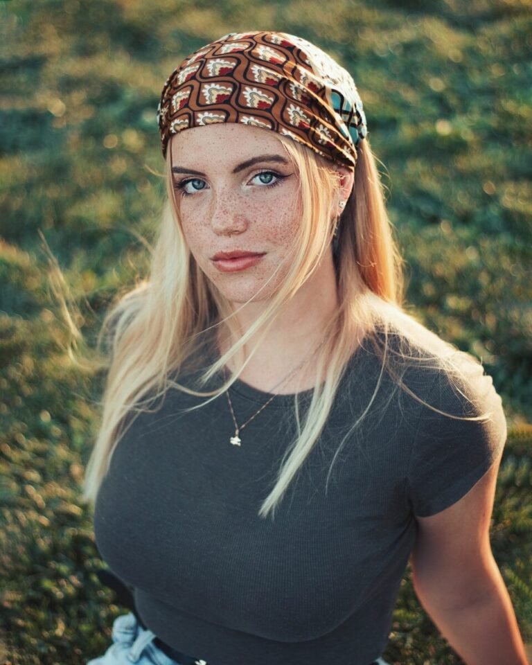 A woman with a bandana on standing in a field