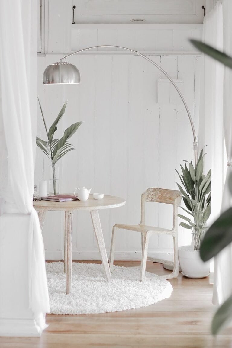 minimalist home design white steel chair in front round table on white rug